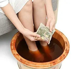 Foot soaking in warm water with Cercrys TCM Foot Soak and herbs for traditional Chinese medicine therapy to relieve fatigue and improve sleep.